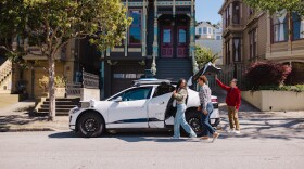 Several riders get into a Waymo vehicle in San Francisco.