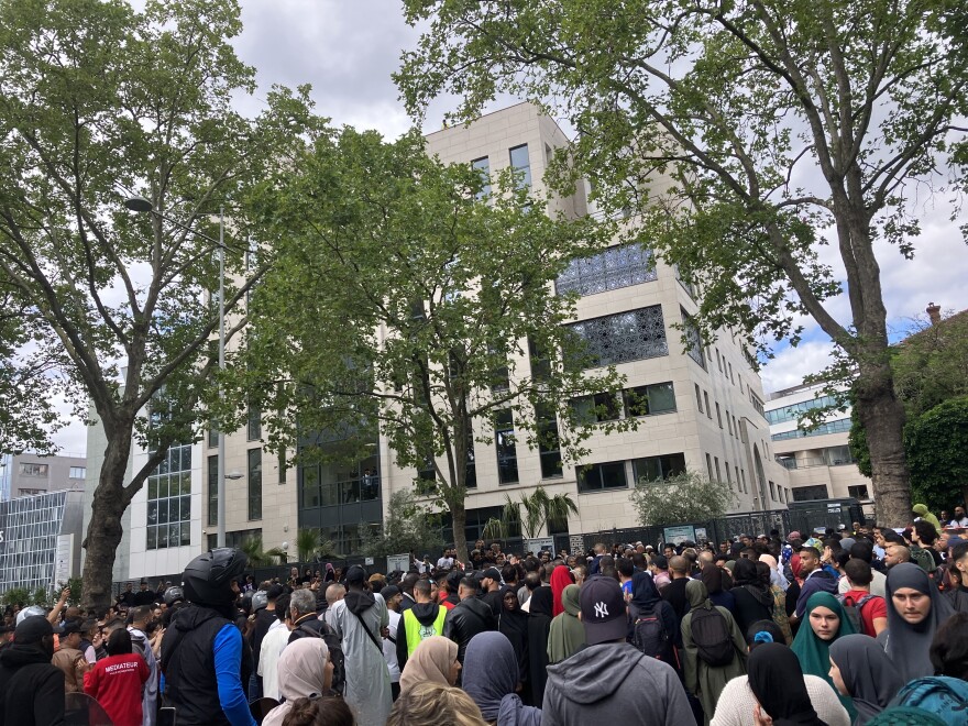 A crowd gathers in front of the Ibn Badis mosque where mourners gathered to pay respects Saturday in Nanterre, France.