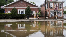 Pedestrians walk along Main Street in Highland Falls, N.Y. on Monday, July 10, 2023 after it was was damaged by flooding the previous day.