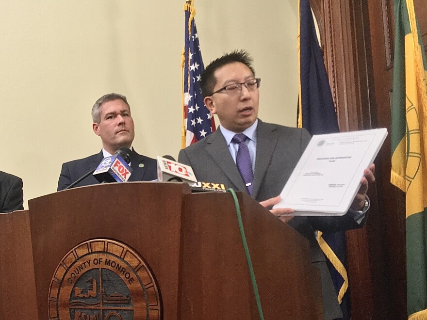 Monroe County public health commissioner Michael Mendoza holds up the county's isolation and quarantine plan at a press conference Tuesday.