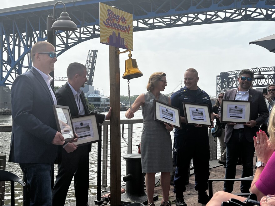  Ohio EPA Assistant Director Mark Johnson, Lake Carriers' Association Vice President Eric Peace, Coast Guard Marine Safety Unit Cleveland Jeremy Maginot Jeremy Maginot, Cleveland Metroparks CEO Brian Zimmerman gather around Northeast Ohio Regional Sewer District CEO Kyle Dreyfuss-Wells as she rings the celebratory "Ring in Summer" bell. 
