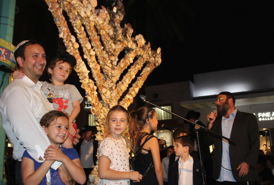 Members of the Miami Beach Jewish community celebrate Hanukkah by lighting the eighth candle on the Lincoln Road seashell menorah on Sunday, Dec. 9, 2018.