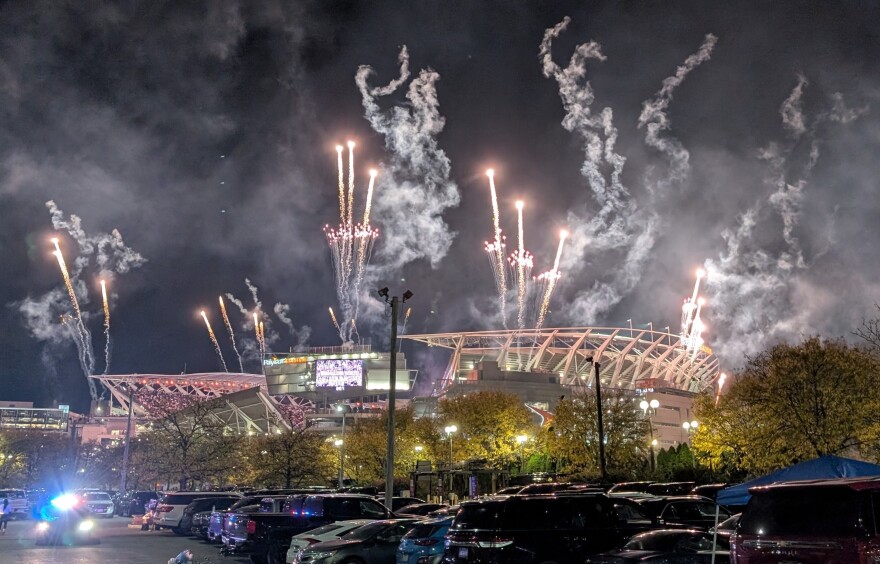 Fireworks explode over a lit-up stadium.