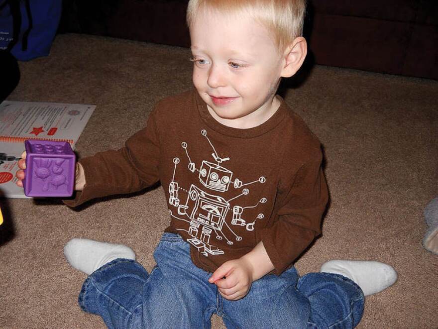 Caleb Hisle plays with colored blocks as part of the HANDS program for first-time parents. The program teaches parents how to interact and bond with their children.