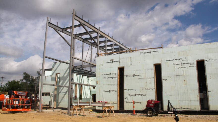 An under construction building with the metal outline of a grand entranceway. 