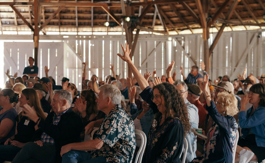 Folks raise their hands to indicate how long they have been listening to KCBX