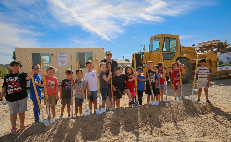 Price Elementary teacher Christina Hall and her students pose with shovels at the groundbreaking site of their new school.