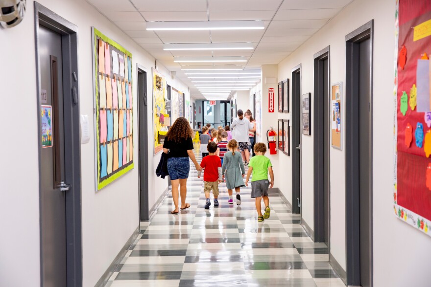 Children walking down a colorful school hallway