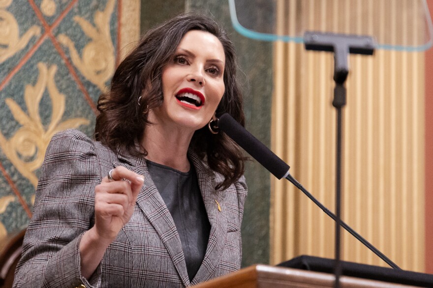 Gov. Gretchen Whitmer stands at a podium in the state capitol.