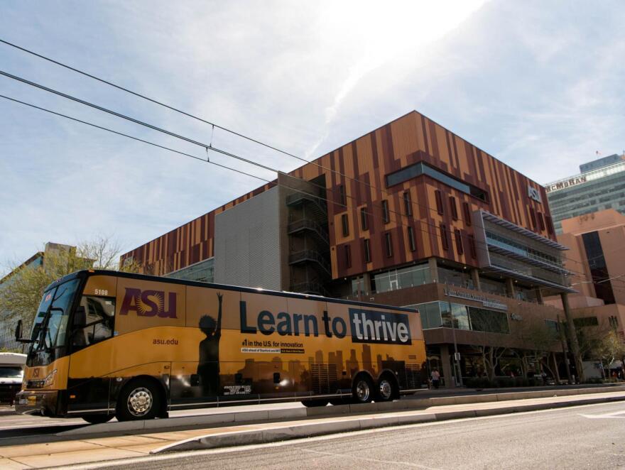 Bus with ASU wrap on road in front of ASU Cronkite building