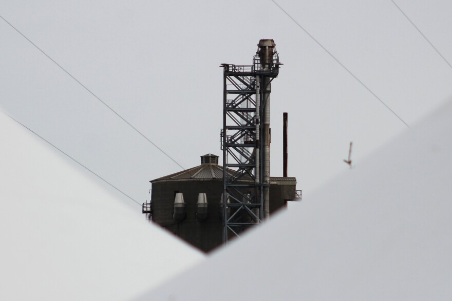 A mothballed fertilizer plant peeks over white event tents on Monday, May 18, 2026 in Nikiski, Alaska.