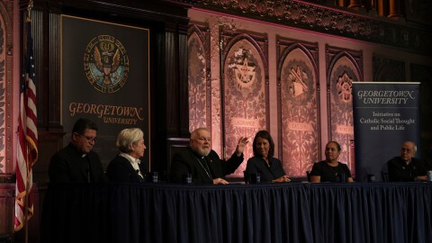 FILE - The archbishop of Miami, Thomas Wenski, raises his hand while addressing a crowd during a panel on immigration at Georgetown University in Washington, Thursday, Sept. 11, 2025.