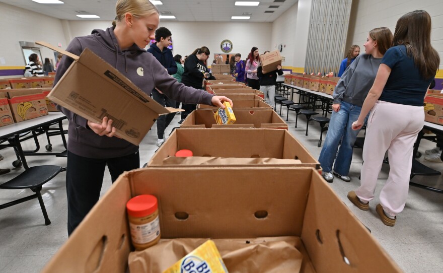 CeCe Franks, a freshman, places butter in a box of Thanksgiving donations.