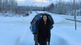 Lucille Williams pulls a cart filled with her belongings on a bike path along Mt. View Drive in January, 2022.(Photo by Adam Nicely/Alaska Public Media)
