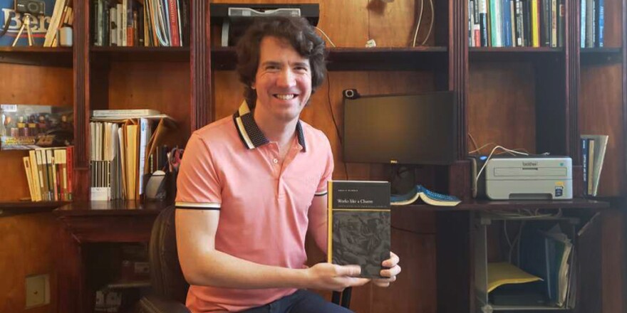 Robert O. McDonald holds a copy of his 2023 book, "Works Like a Charm: Incentive Rhetoric and the Economization of Everyday Life" (SUNY Press).