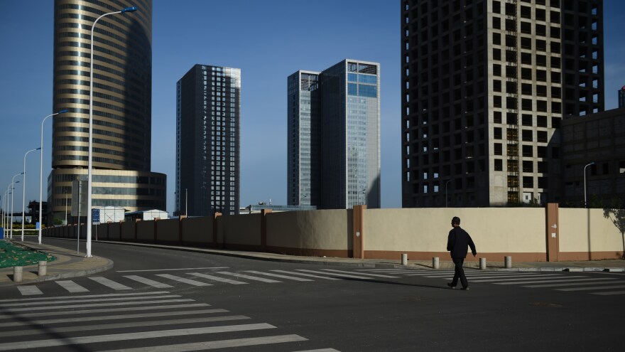 A man walks in an empty street in Conch Bay opposite the new Yujiapu Financial District in Tianjin, China, in 2015.