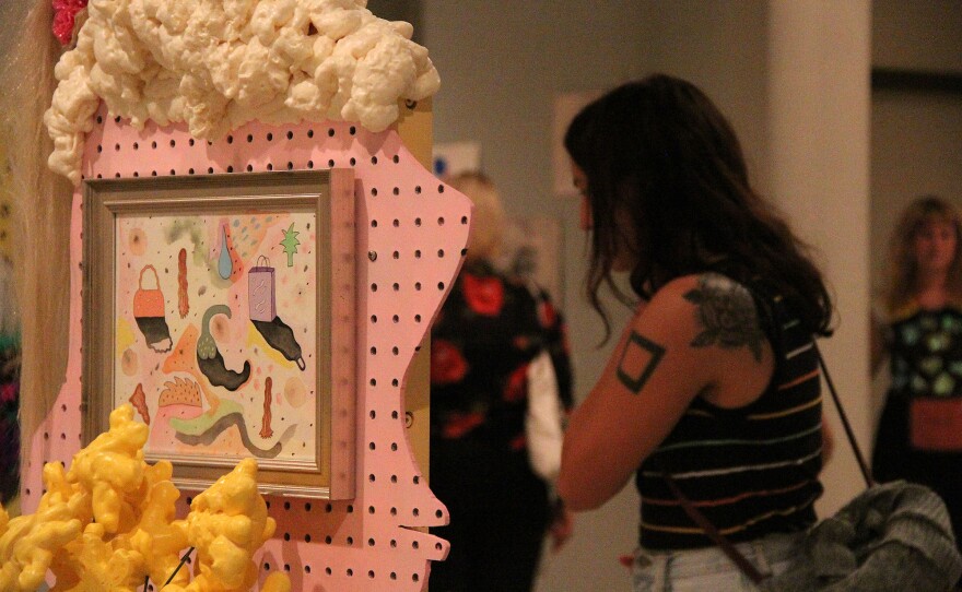 COLORS AND HAIR – An art show attendee checks out the work of artist Dessarae Bassil on Friday at The Wooly. (photo by Christena Carollo)