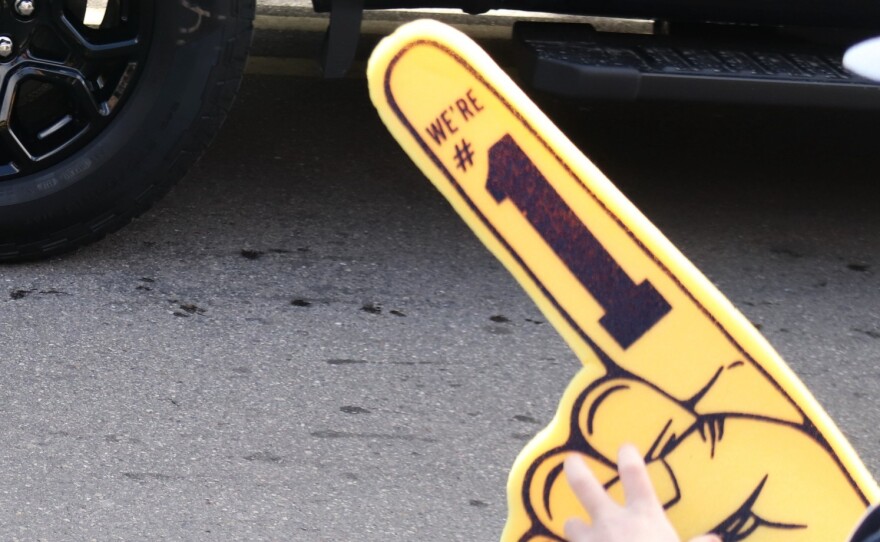 A child with a foam finger that says "we're number one."