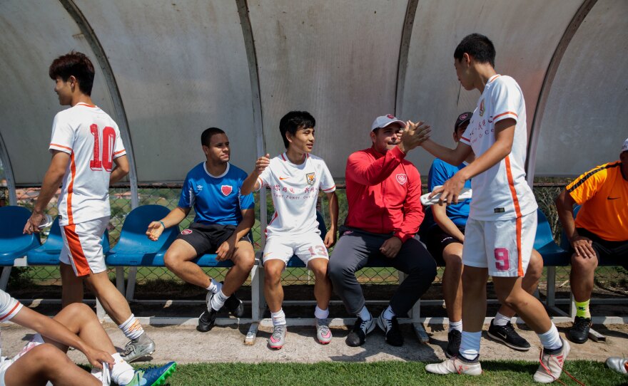 Chinese soccer players shake hands with coach Leonardo Galbes and other instructors after practice.