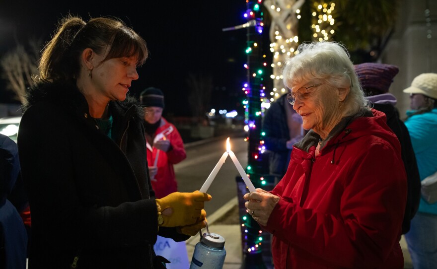 City council member Cassidy Santaguida, left, and Jeannie Lennon, right, light candles during a vigil for Renee Good and other victims of ICE violence on the steps of the Alton Lennon Federal Building in downtown Wilmington on January 14, 2025. Community members listened as organizers with Siembra NC and elected officials spoke and honored the victims.