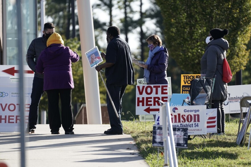 Voters are assisted at a polling location at the South Regional Library in Durham, N.C., on Nov. 3, 2020. U.S. Magistrate Judge Joe Webster said Tuesday, January 3, 2023, that a North Carolina law that makes it a serious crime for someone to vote while still on probation or parole for a felony conviction shouldn’t be thrown out.(AP Photo, Gerry Broome, file)