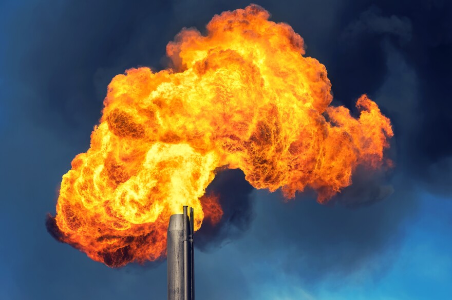 Billowing fiery smoke pours out of a factory.