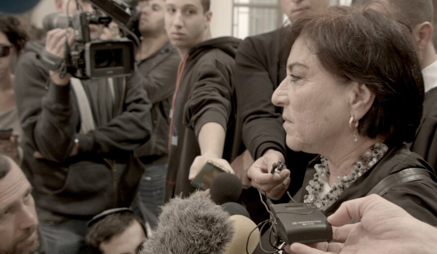 Israeli lawyer Lea Tsemel is shown in <em>Advocate</em> speaking to a scrum of reporters at a Jerusalem courthouse.