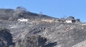 Firefighters look for Sandy Fire hot spots in the hills south of Rocking Horse Drive in Simi Valley Thursday.