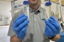 Revive Environmental CEO David Trueba holding samples of AFFF (pictured right) and the result after processing the the PFAS annihilator (pictured left): water.