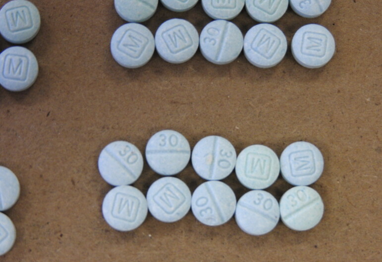 Blue fentanyl pills lined up in groups of 10.