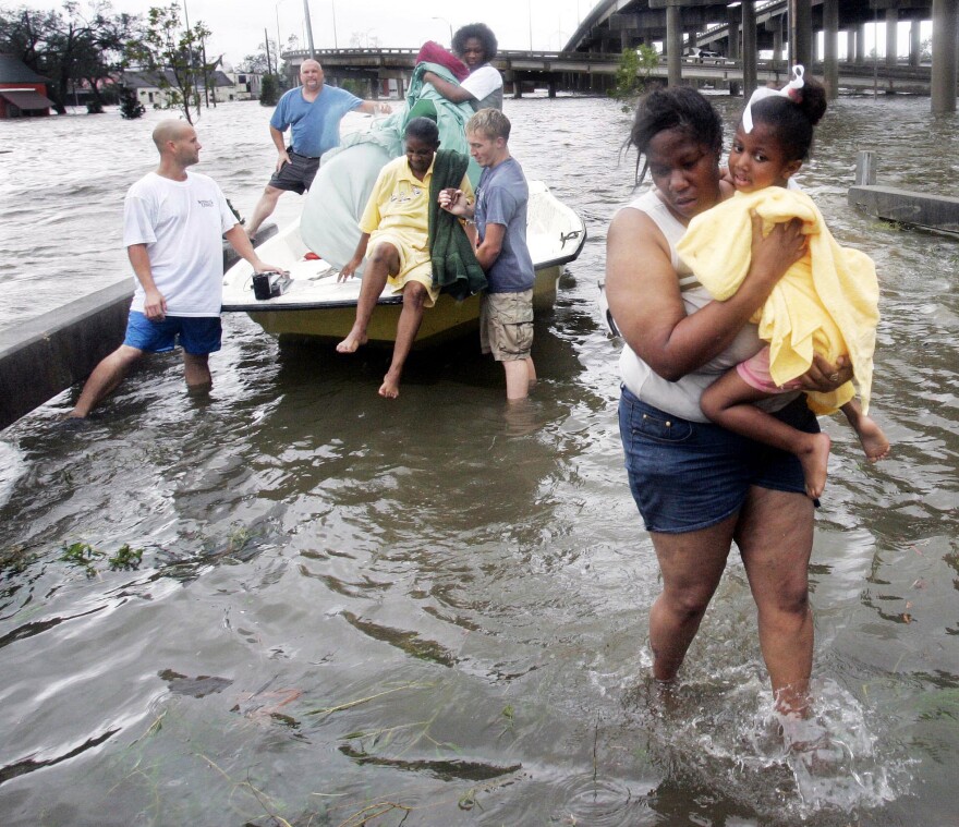 Shante Gruld carries Janeka Garner, 5, to safety after they were rescued from their flooded home by boat in New Orleans on Aug. 29, 2005. The area was flooded after Hurricane Katrina hit the area.