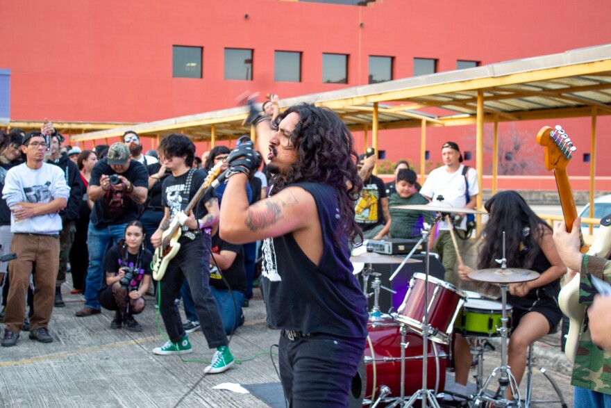The punk rock band called W.I.M.P performs at the central library's parking garage.