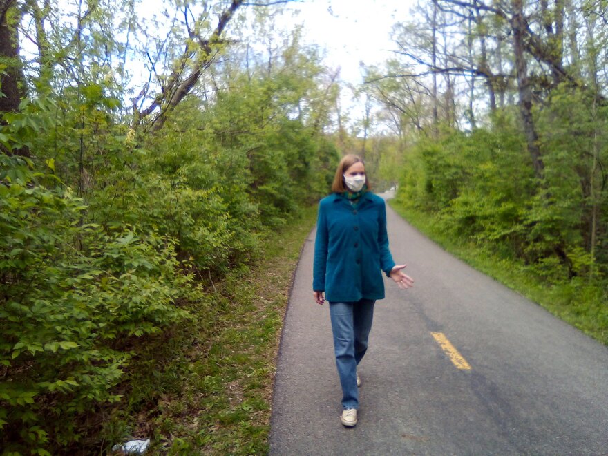 Photo of Jennifer Hambric walking with mask on waving.