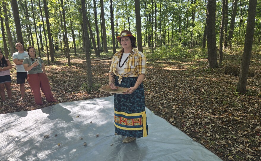 Cortney Collia demonstrates how to use a birch basket to winnow the rice.