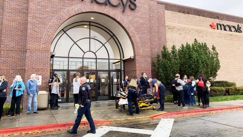 A crowd of people gather outside of Macys at the Boise Towne Square mall as a victim of the Monday, Oct. 25th, 2021 shooting is loaded onto a gurney. 