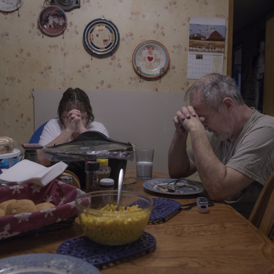 Kelly and his wife, Lisa, say grace before Sunday dinner.