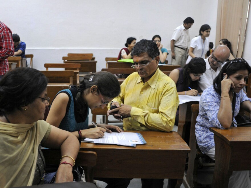 Parents help their children fill out applications at Delhi University's Shri Ram College of Commerce in New Delhi, India, on June 16. The College of Commerce is considered one of the most difficult to get into.