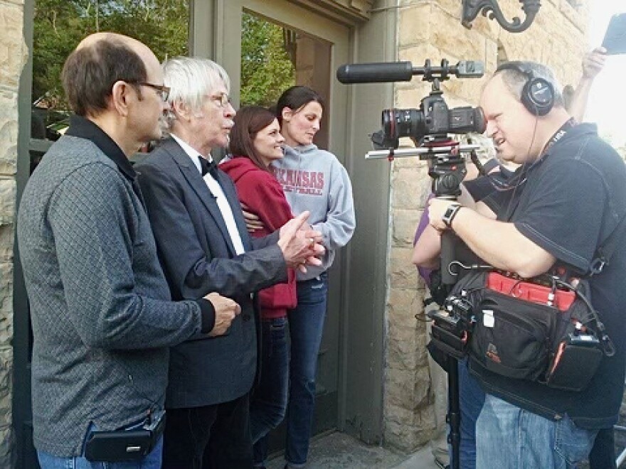 Zeek Taylor, wearing a black bow tie, with spouse Dick Titus, field media questions on the Eureka Springs Courthouse steps, May 10th, 2014, along with Jennifer and Kristin Seaton-Rambo.