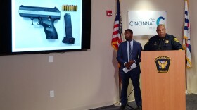 City Manager Patrick Duhaney and Police Chief Eliot Isaac display a picture of the handgun recovered from the scene.