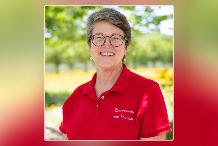 A smiling shirt-haired woman with a red polo shirt that says Jane Ragsdale.