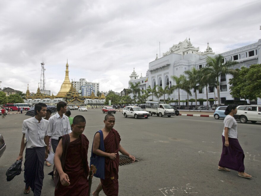 Buddhist monks and others walk across a road in downtown Yangon, Myanmar, on May 13.