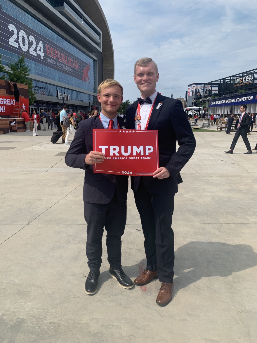 two young people holding a Trump sign