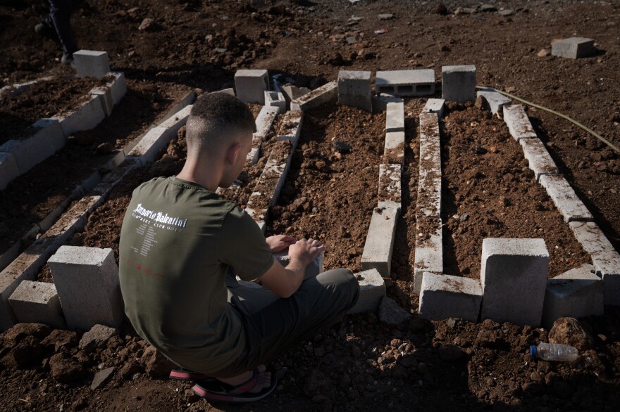 A young man sits by the fresh graves of the two teenagers and one twenty year old Killed in the recent Israeli drone strike in Jenin, occupied West Bank.