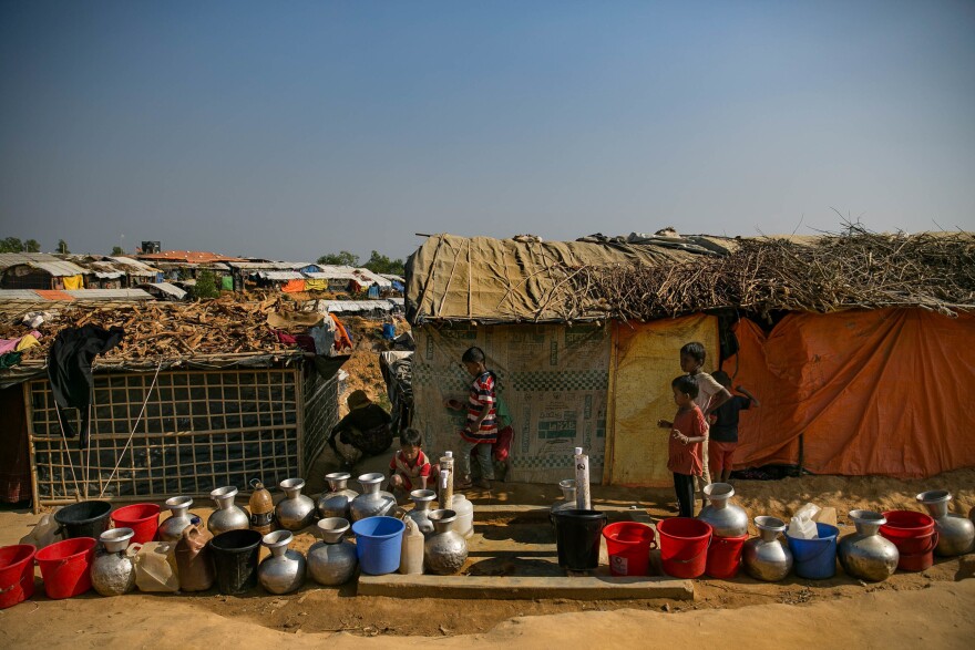 Kids wait for the water taps to be turned on in the Hakimpara camp.