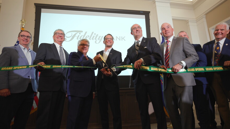 Daniel J. Santaniello, Fidelity Bank President and Chief Executive Officer, cuts a ribbon to open the bank's new corporate headquarters alongside Pennsylvania Governor Josh Shapiro and other bank and elected officials.