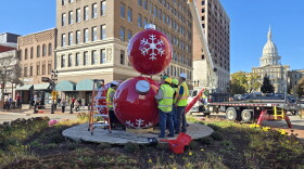 Crews helping lower the final red ornament ball onto the others in downtown Lansing