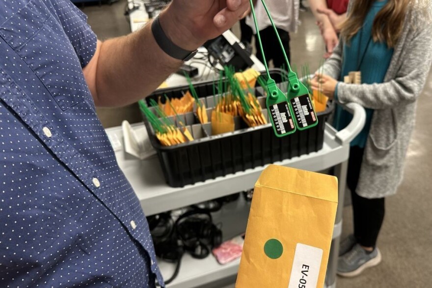 Deputy Director of Elections Brent Stinson displays a green seal that will be used to lock down a ballot scanner during Marion County’s public test day on Oct. 4. They are used to indicate potential tampering. Each seal has a unique serial number.