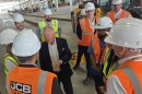 Lord Anthony Bamford, the chair of JCB, is surrounded by employees during a tour of its future San Antonio plant site on March 30, 2026