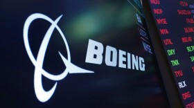 The logo for Boeing appears on a screen above a trading post on the floor of the New York Stock Exchange.