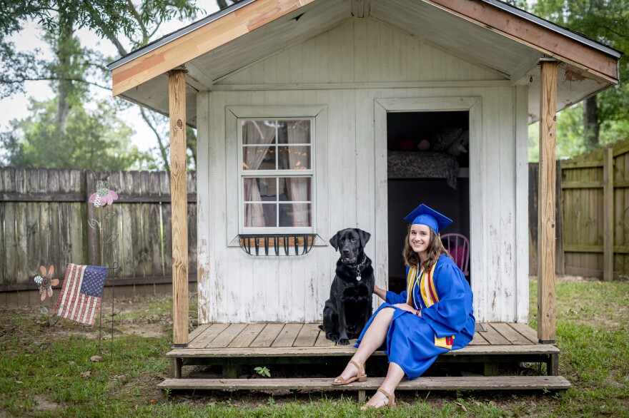 East Ascension High School Valedictorian Emma Cockrum with her dog Hercules in front of her old play house at her home in Prairieville, La.